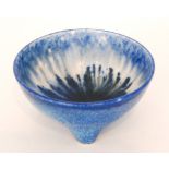 A small Ruskin Pottery crystalline glaze tri-footed bowl decorated in a streaked and tonal blue