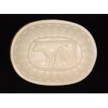 A 19th Century jelly mould with a cow creamer and milk maid to the centre, length 18cm.