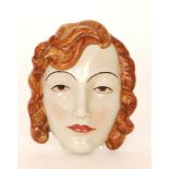 A 1930s Art Deco face mask formed as a lady with brown curly hair, impressed C. Ltd England No.