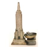 A 1930s Art Deco cast metal vesta and ashtray formed as the Empire State building, height 18cm.