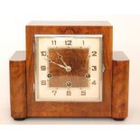 An Art Deco walnut eight day strike mantle clock with Arabic numerals to a square dial,