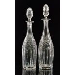 A pair of early 20th Century John Walsh Walsh clear crystal decanters of slender bottle form each