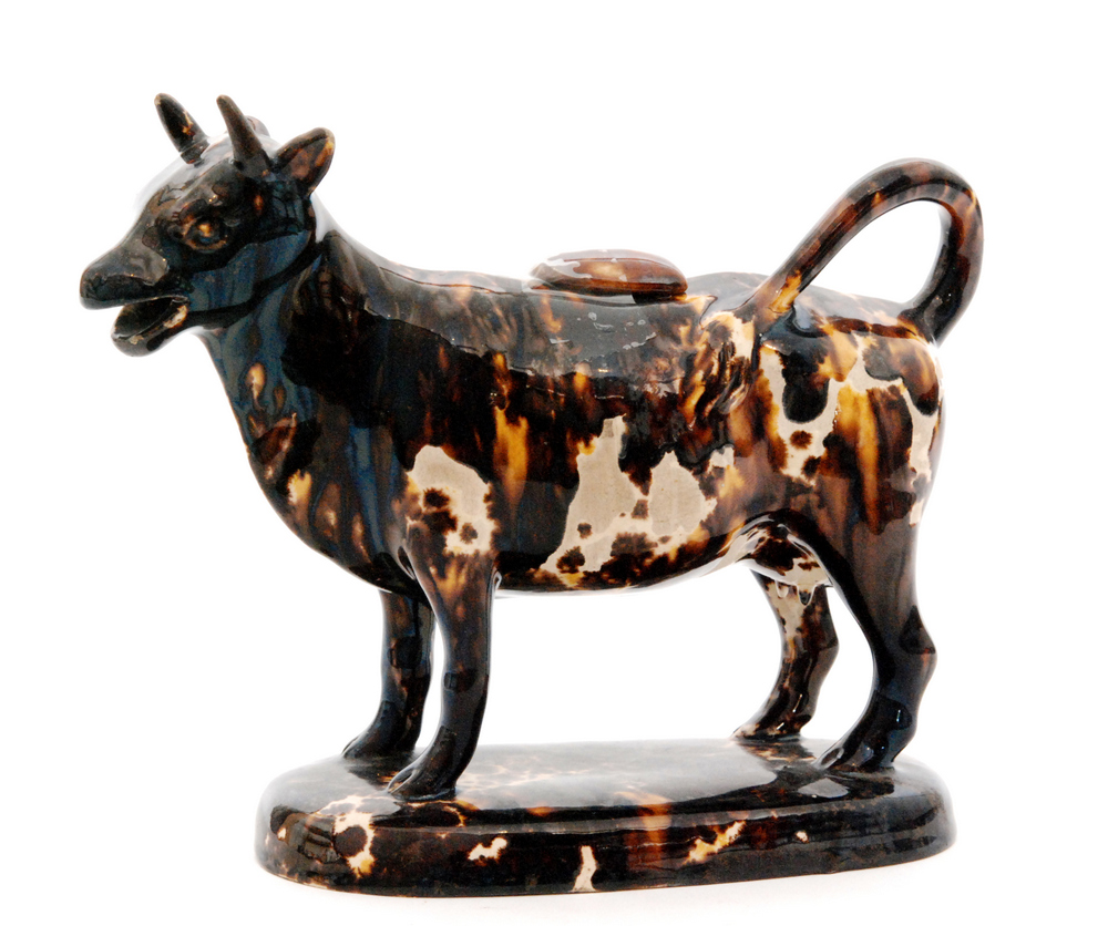 A late 18th Century Staffordshire Neale Pottery cow creamer and cover decorated in an all over