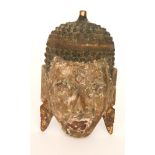 A carved wooden face mask of a Buddha, possibly depicting Maitreya,