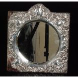 A silver easel mirror, circular glass within a pierced and foliate decorated silver mount,