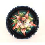 A Moorcroft footed bowl decorated in the Columbine pattern with a central tubelined flower against