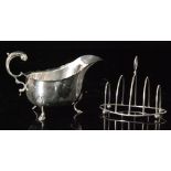 A hallmarked silver sauce boat raised on three stepped feet and terminating in acanthus capped