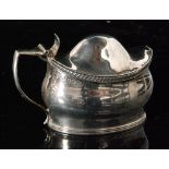 A George III hallmarked silver boat shaped mustard pot and cover with reeded and gadroon borders