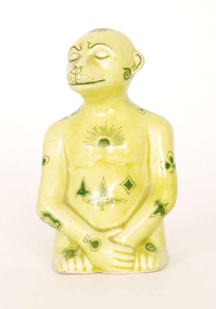 An early 20th Century model of a seated mythical monkey type creature glazed in yellow with green