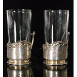 A pair of continental silver Art Nouveau tea glass holders detailed with flower and leaf borders