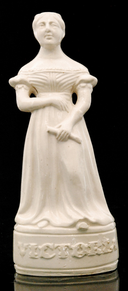 A 19th Century Stephen Green salt glaze decanter bottle modelled as Queen Victoria holding a scroll