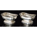 A pair of George IV hallmarked silver boat shaped open pedestal salts of plain for with gadroon