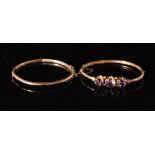 A Victorian rose gold and amethyst hinged bangle centrally set with three mixed cut collar set