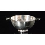 A hallmarked silver quaich of plain from terminating in strut side handles, diameter 11cm,