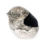 An Edwardian hallmarked silver pin cushion modelled as a hatching chick with blue velvet cushion,