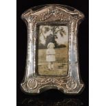 An Edwardian style hallmarked silver rectangular easel photograph frame with embossed ribbon and