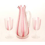 A late 19th Century Stourbridge glass water jug of footed conical form with applied fluted handle,