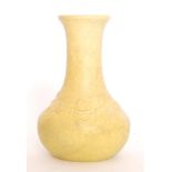 Ruskin Pottery - A bottle vase decorated in an all over matt yellow with moulded prunus blossom to