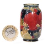 William Moorcroft - A miniature barrel vase decorated in the Pomegranate pattern with a band of