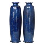 Ruskin Pottery - A pair of souffle glaze 'rolling pin' vases each decorated in a mottled blue with