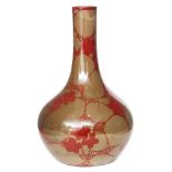 Bernard Moore - A small early 20th Century vase of globe and shaft form decorated with ruby lustre