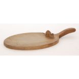 Robert 'Mouseman' Thompson - A single handled oak cheeseboard of oval form, with adzed finish,