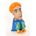 Clarice Cliff - Seated Arab - A novelty figure of a seated sleeping Arab with orange painted turban