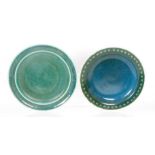Ruskin Pottery - Two footed plates each decorated with a dark green souffle glaze,