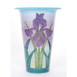 A Dennis China Works trumpet vase decorated with tubelined purple iris against a tonal blue and