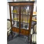 An Edwardian line and marquetry inlaid display cabinet enclosed by a pair of bar glazed doors over