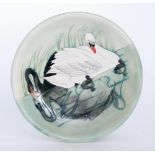 A Moorcroft Pottery wall plate decorated in the Swan pattern with two tubelined swans and two