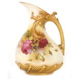 A Royal Worcester shape 1439 ewer decorated with hand painted crimson roses against a pale ground,