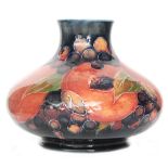 A Moorcroft vase of compressed form decorated in the Pomegranate pattern with a band of whole and
