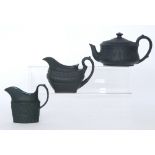 Three pieces of black basalt comprising a 1930s Wedgwood teapot of compressed form decorated in low