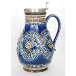 A late 19th Century Doulton Lambeth silver plated lidded jug decorated with a raised band of