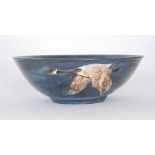 A contemporary pottery bowl by Lisa B Moorcroft decorated with tubelined geese in flight over a