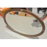 An Arts and Crafts beaten copper framed oval wall mirror with lozenge mounts,