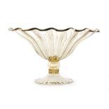 A large early 20th Century Italian Murano glass bowl of fluted circular form with a folded rim,