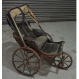 A Victorian black and red line painted three wheel perambulator with black padded seat and canopy,