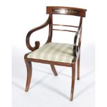 A late Regency mahogany elbow chair with brass inlaid yoke,