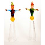 A pair of later 20th Century novelty champagne glasses with multicoloured figural stems over a