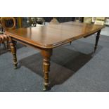 A William IV style mahogany extending dining table the moulded edge top over a plain frieze on