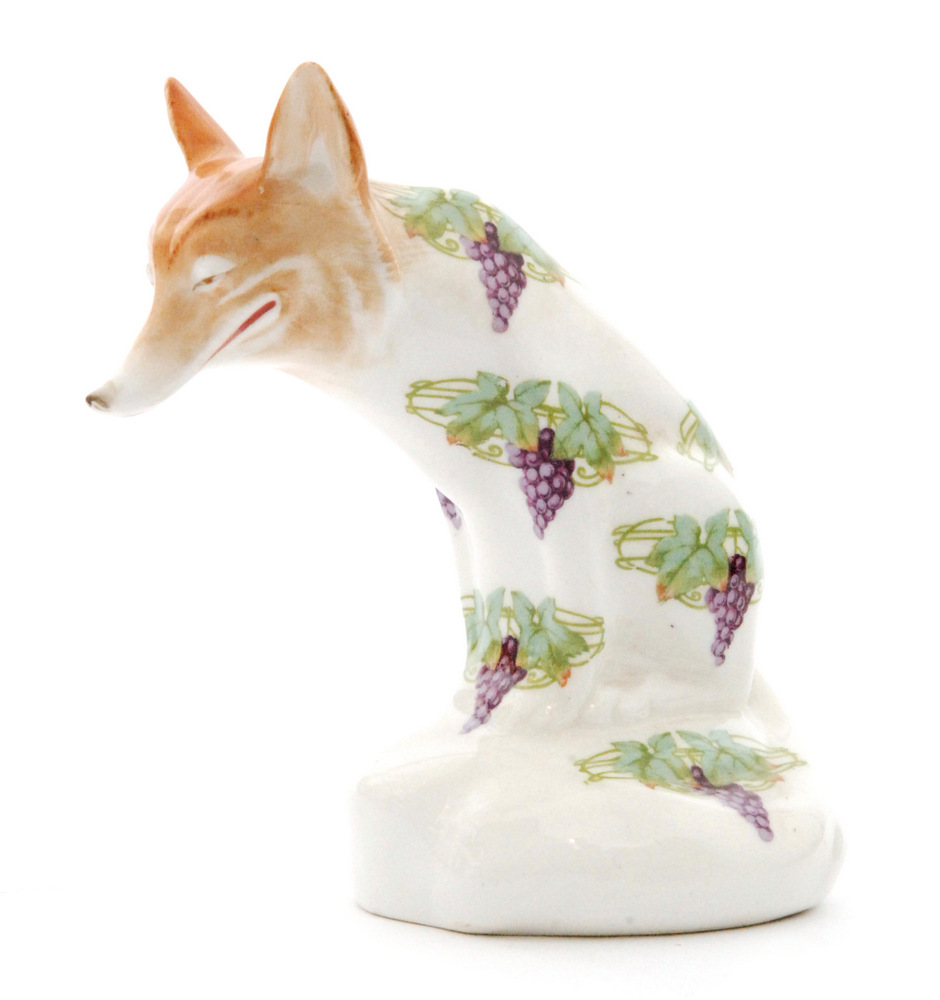 An early 20th Century Royal Doulton model of a seated fox with a wide grinning face,