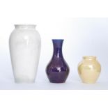 Three Moorcroft lustre glaze vases comprising a mallet vase glazed in an all over mottled purple,