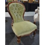 A Victorian mahogany framed balloon back easy chair upholstered in pale green buttoned plush on