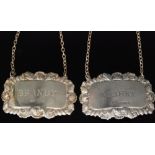 Two hallmarked silver rectangular decanter labels Brandy and Whisky within shell and acanthus leaf