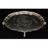 A hallmarked silver salver of plain form with central presentation engraving within floral and