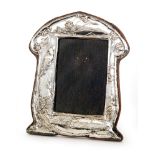 An early 20th Century hallmarked silver shaped easel photograph frame decorated with a bird perched