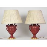 A pair of urn shaped Adams style cinnabar two handled Table Lamps, decorated with foliage,