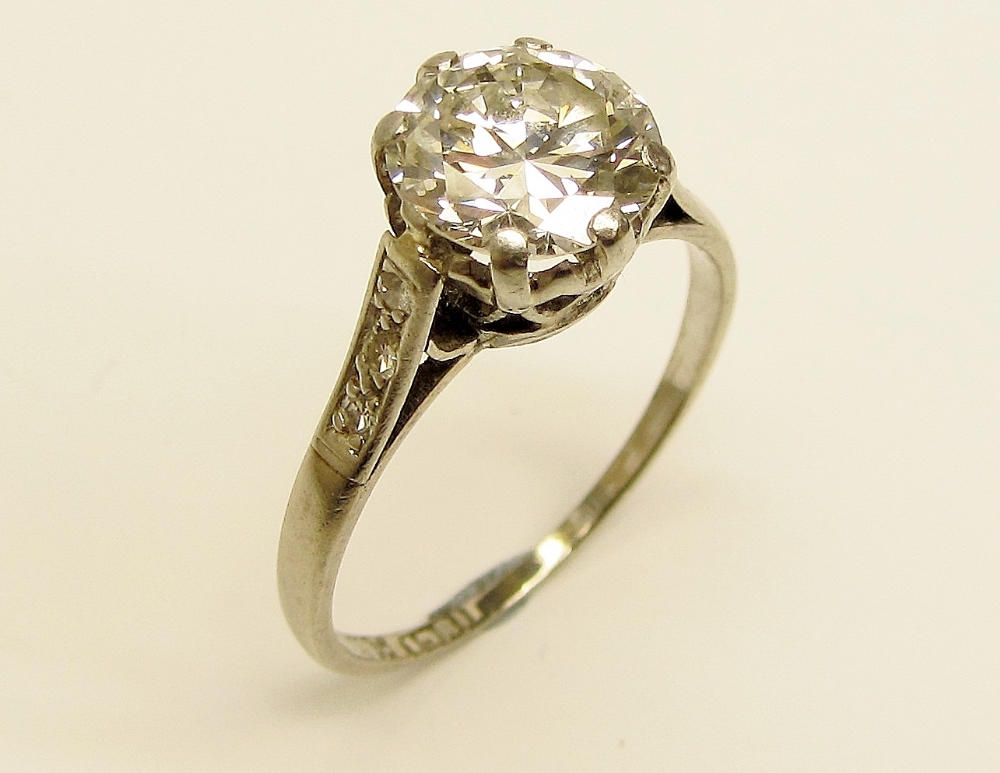 An elegant and desirable 8 claw Rex setting Pave set Ring, with a central round brilliant 2ct,